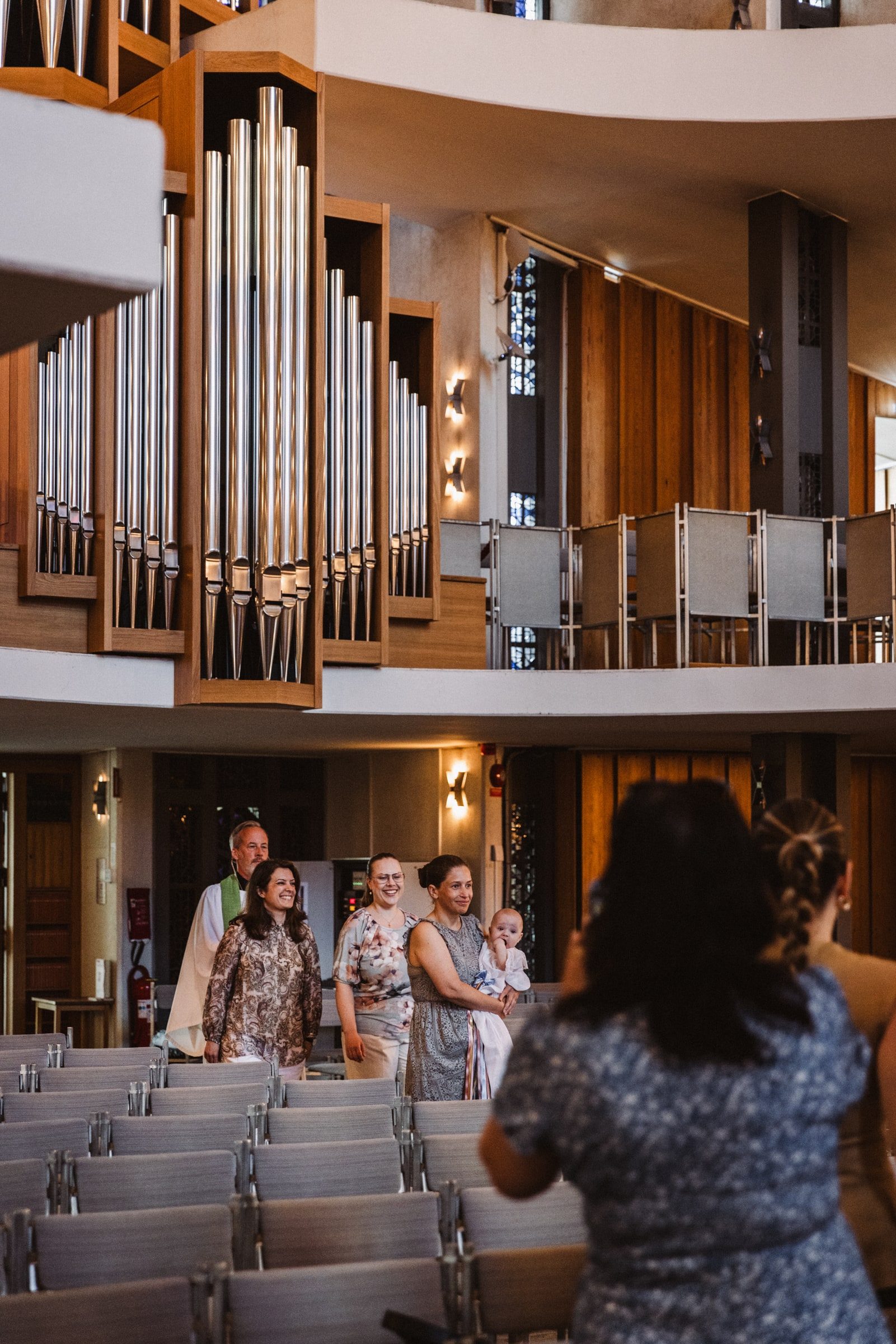 Pipe organ and curved architecture inside the church before a baptism.