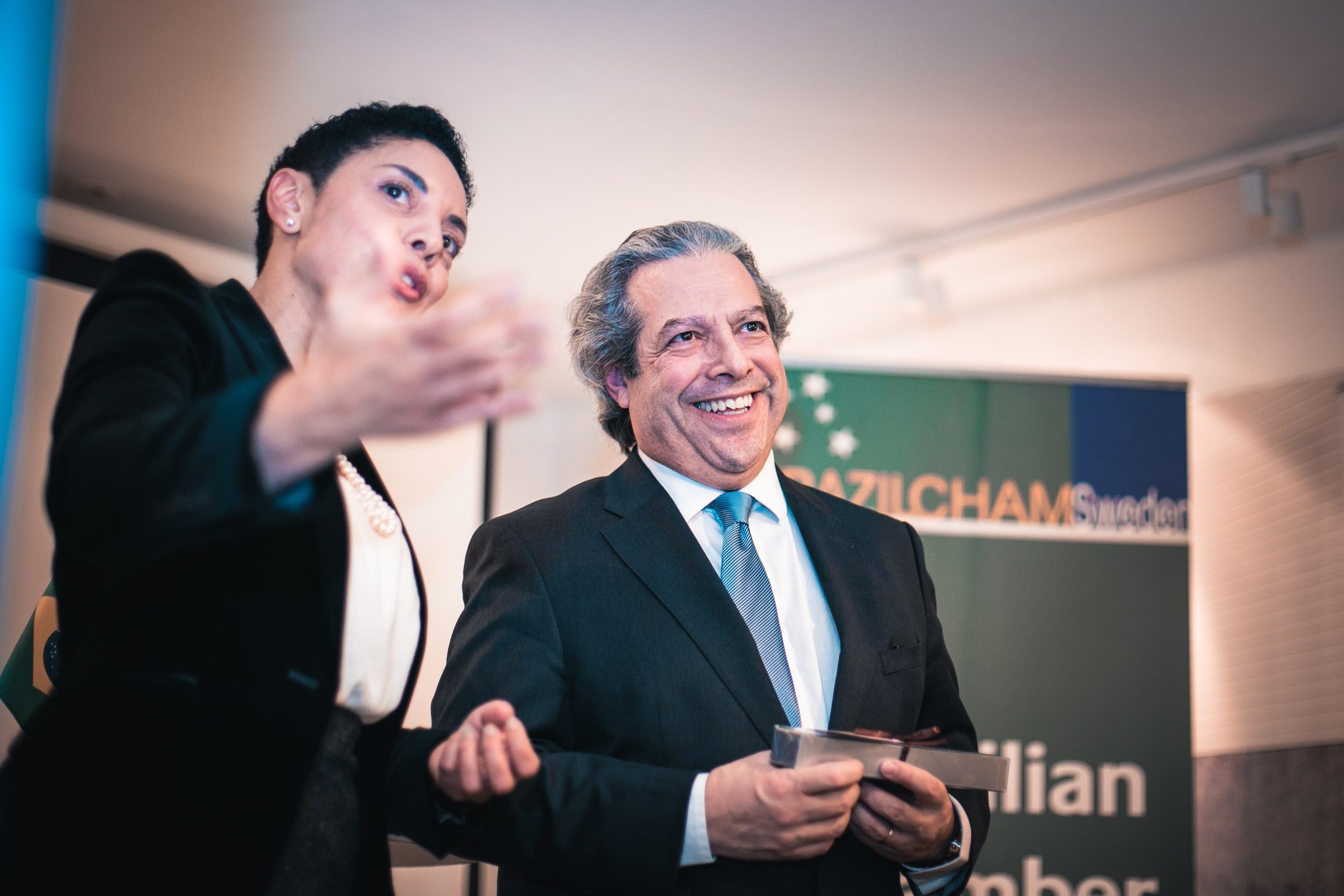 Woman gesturing during a formal exchange with a reception guest.
