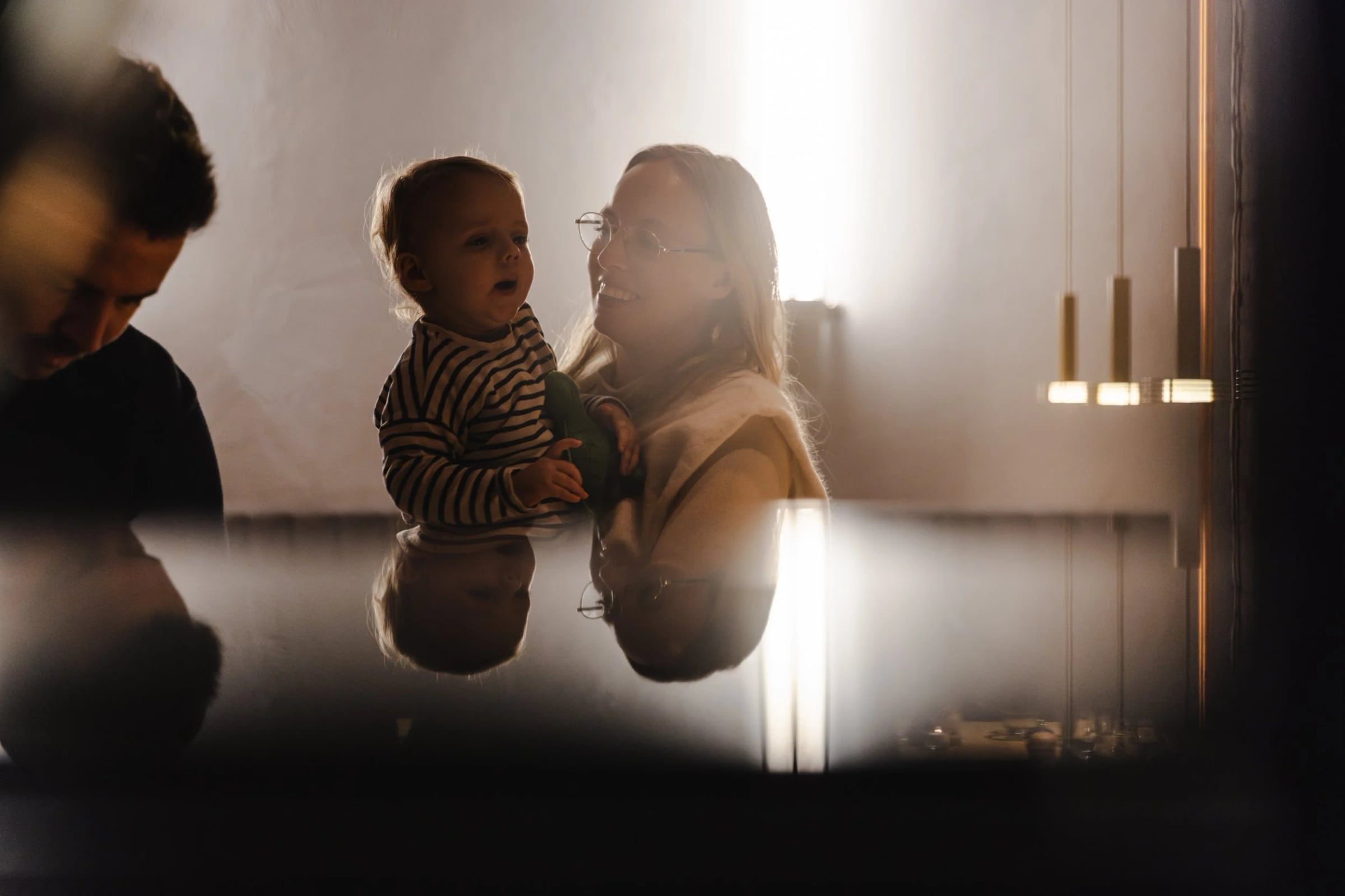 Parent holding a child among guests at the restaurant opening