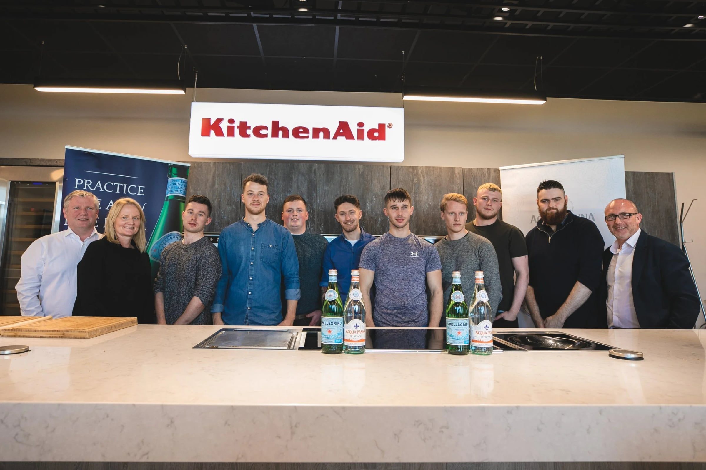 Wide group portrait at the end of the KitchenAid cooking workshop