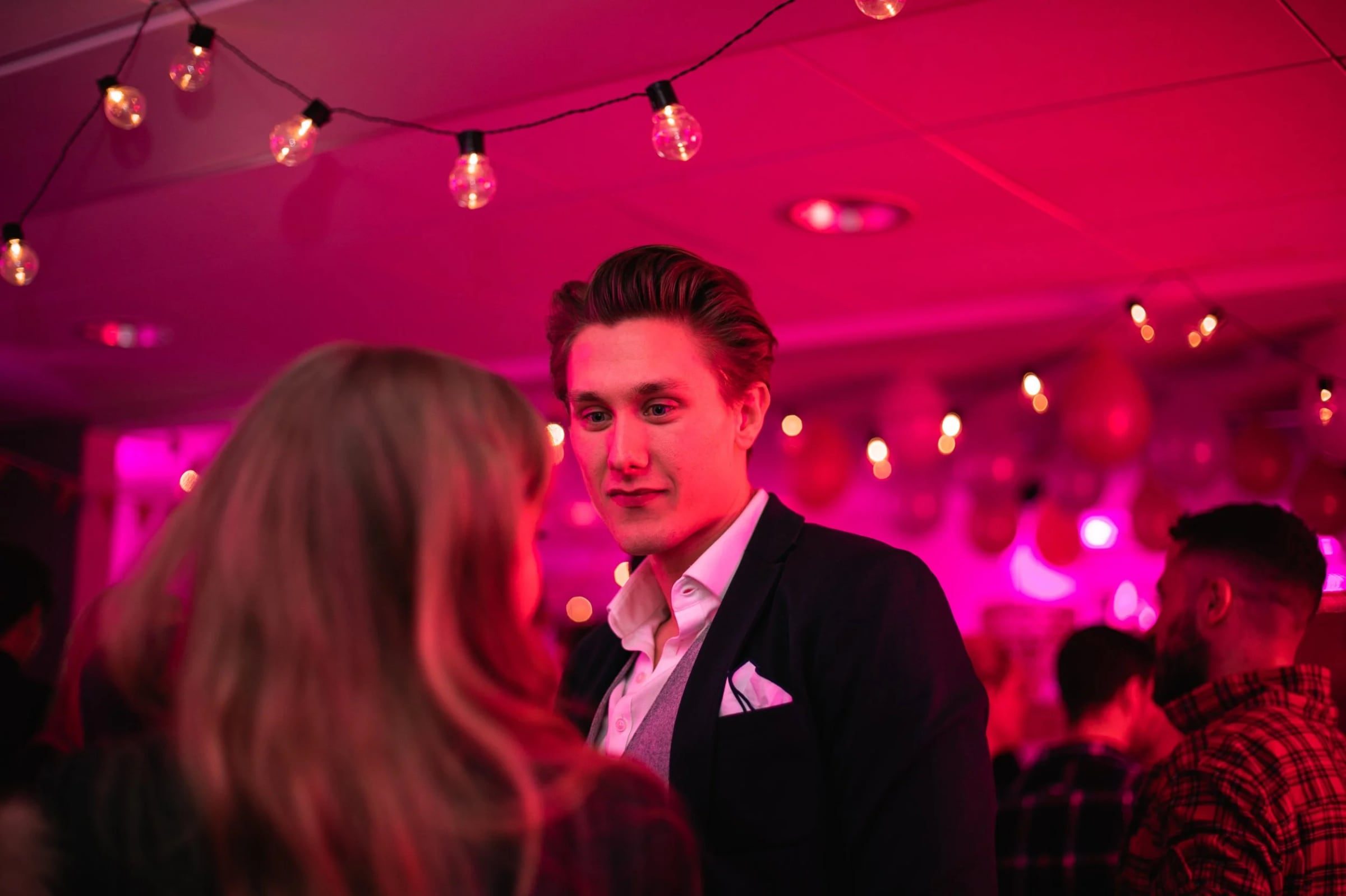 Man in a suit talking with guests at the company reception