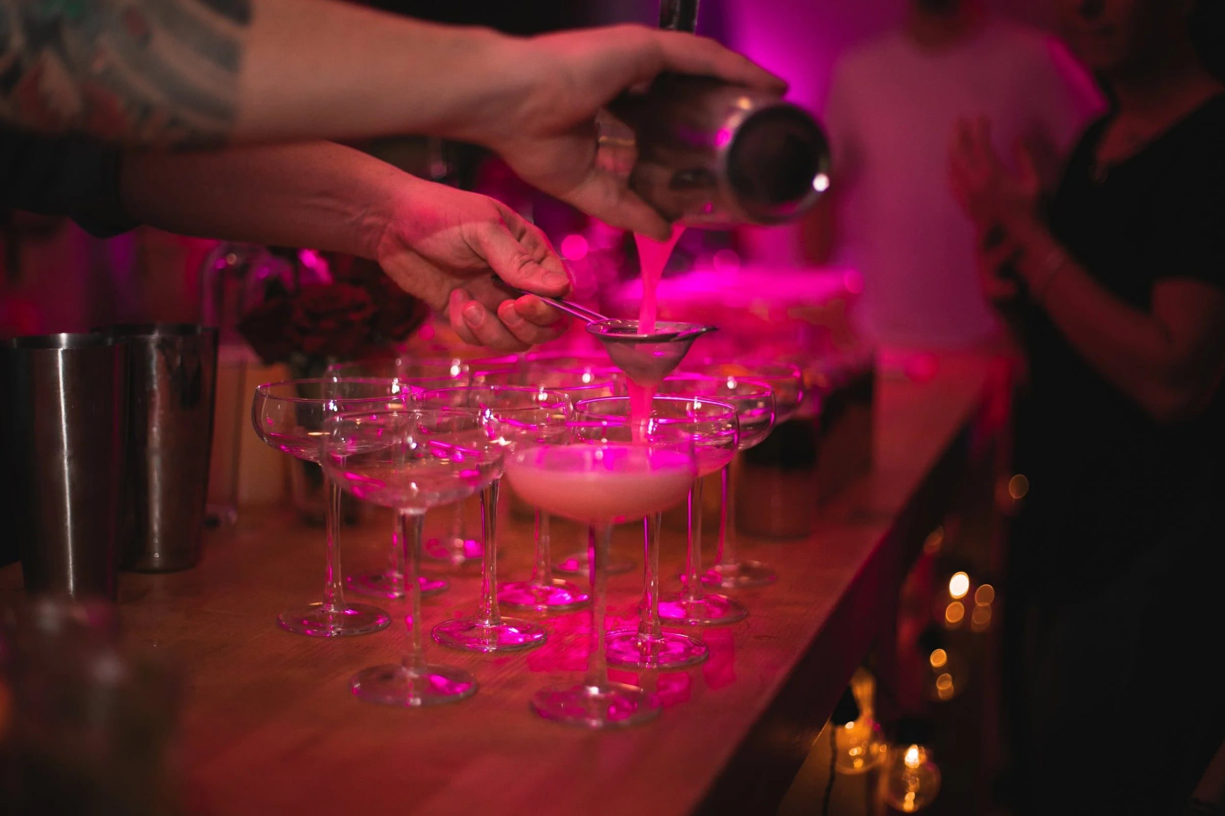 Bartender pouring cocktails at the bar during Relatable’s anniversary celebration