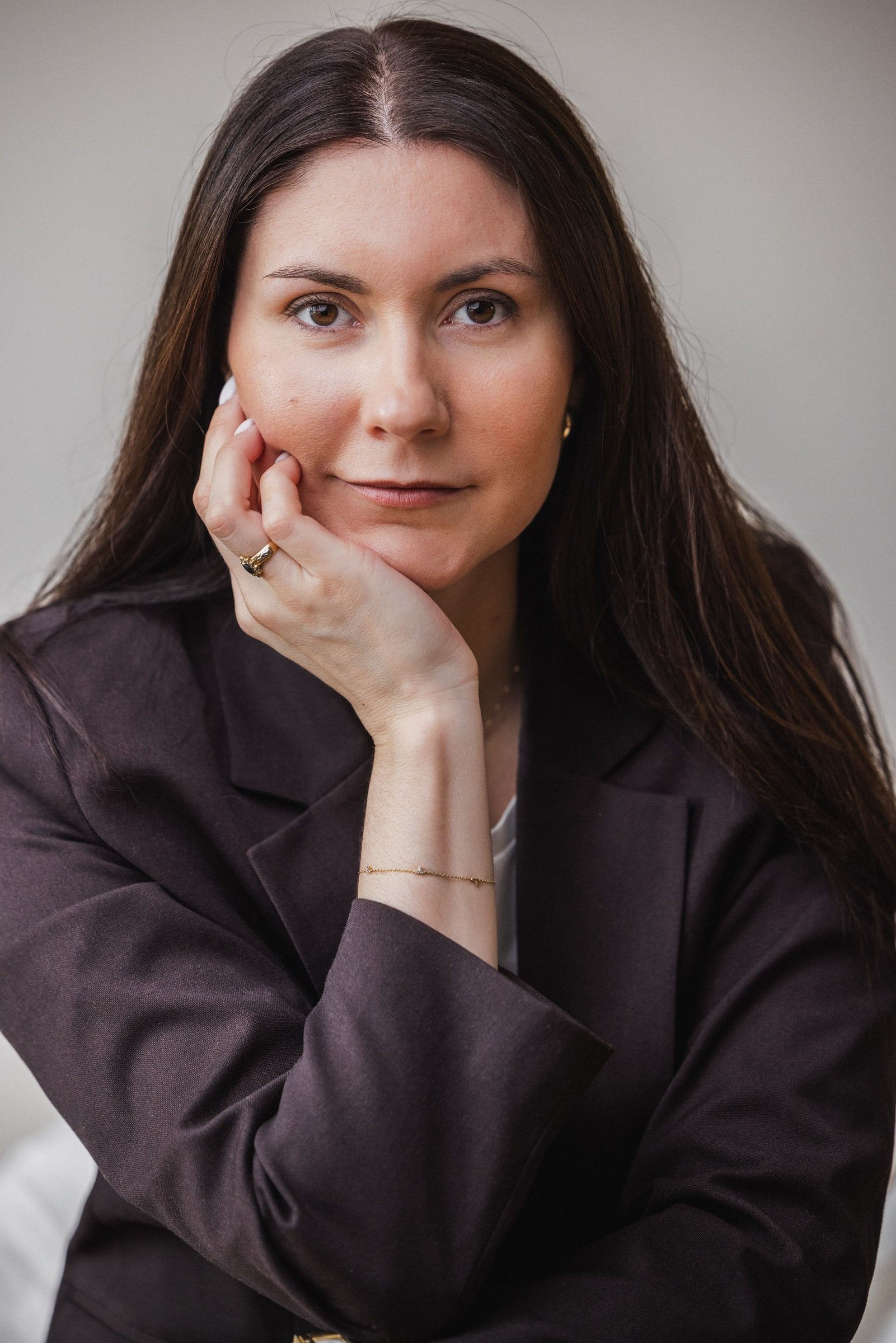 Close professional portrait of a business coach resting her chin on her hand.
