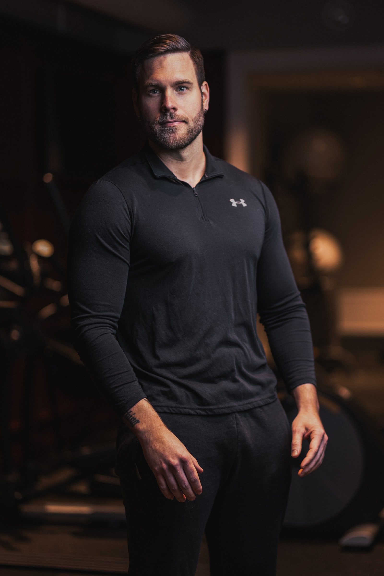 Professional portrait of a personal trainer inside a gym.