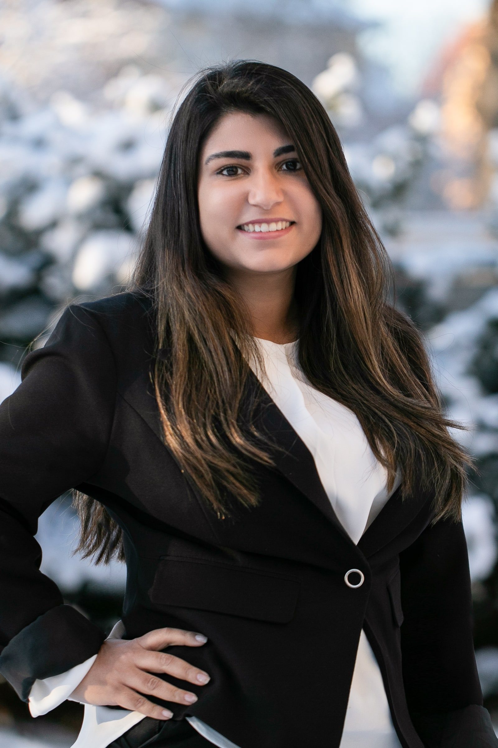 Close team portrait of a woman with long dark hair wearing a black blazer.