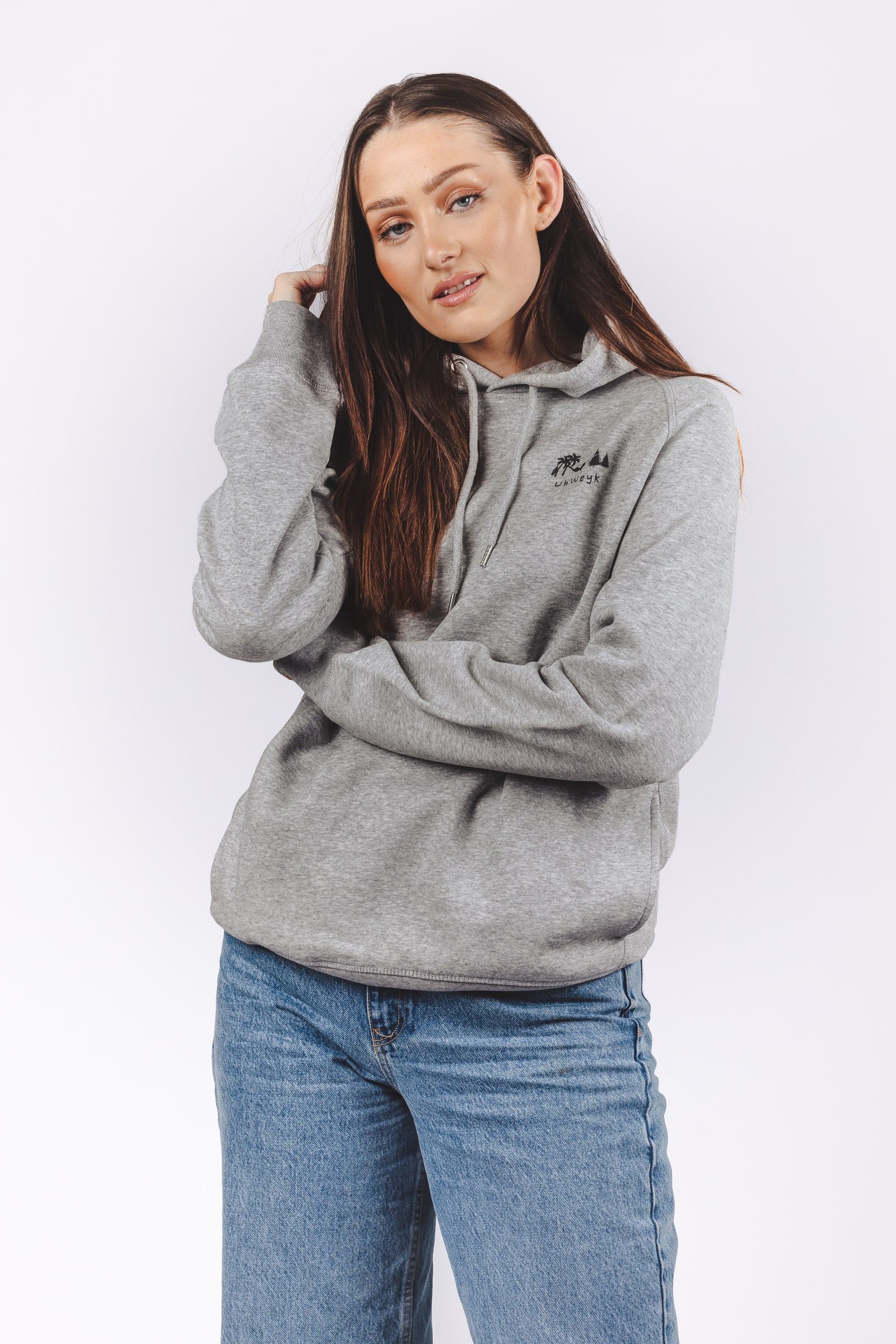 Model wearing a grey hoodie in a clean studio portrait.