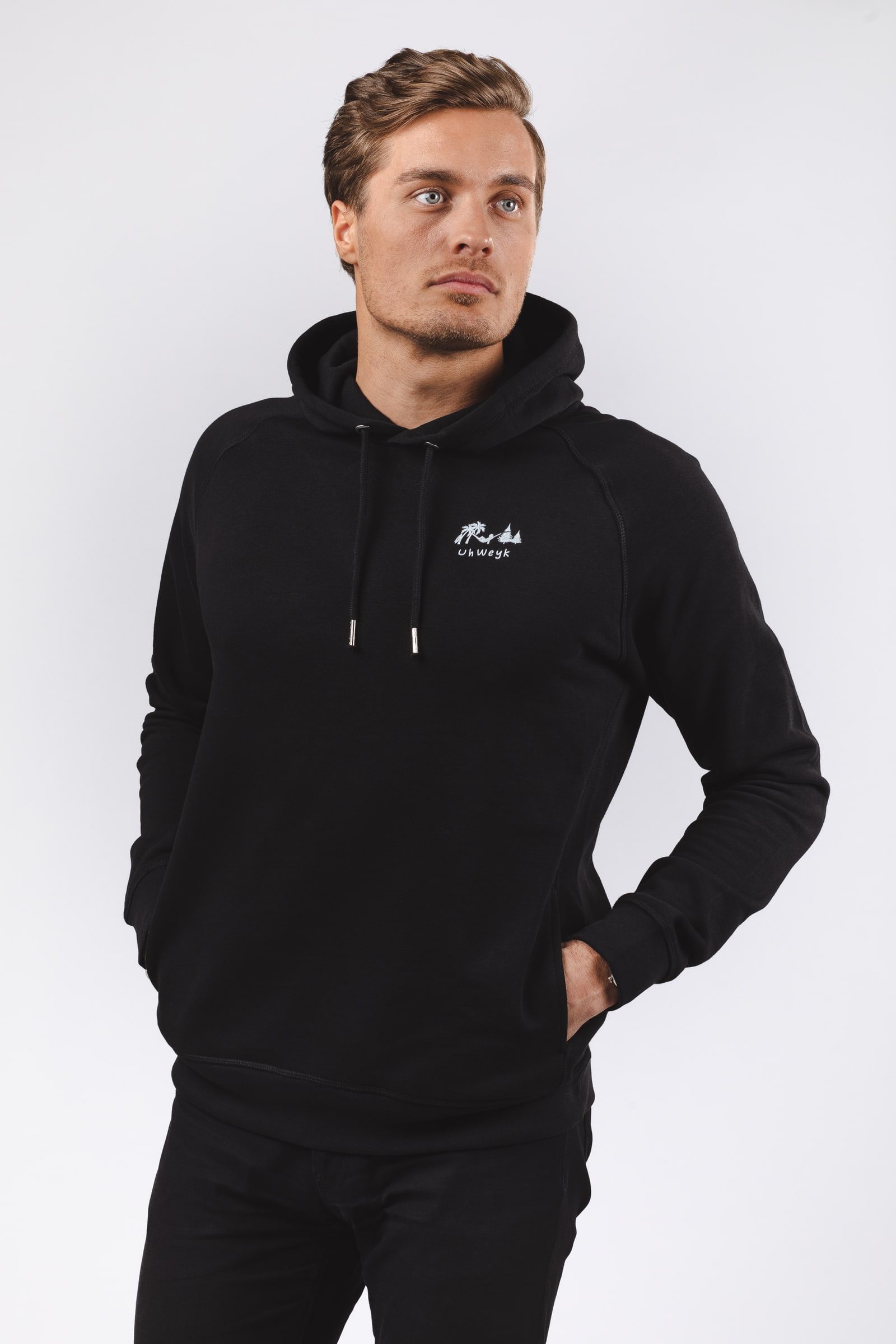 Male model wearing a black hoodie for an e-commerce portrait.