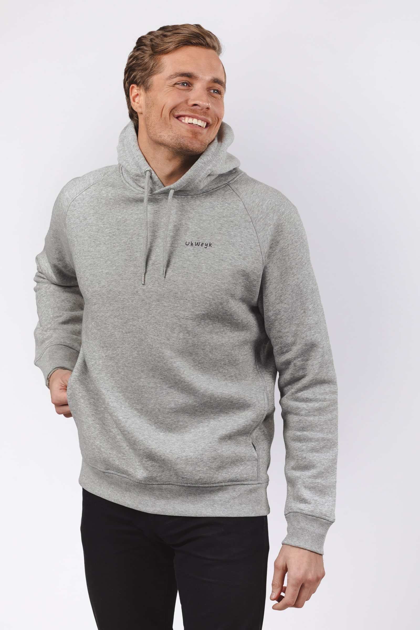 Male model wearing a grey branded hoodie against a white background.