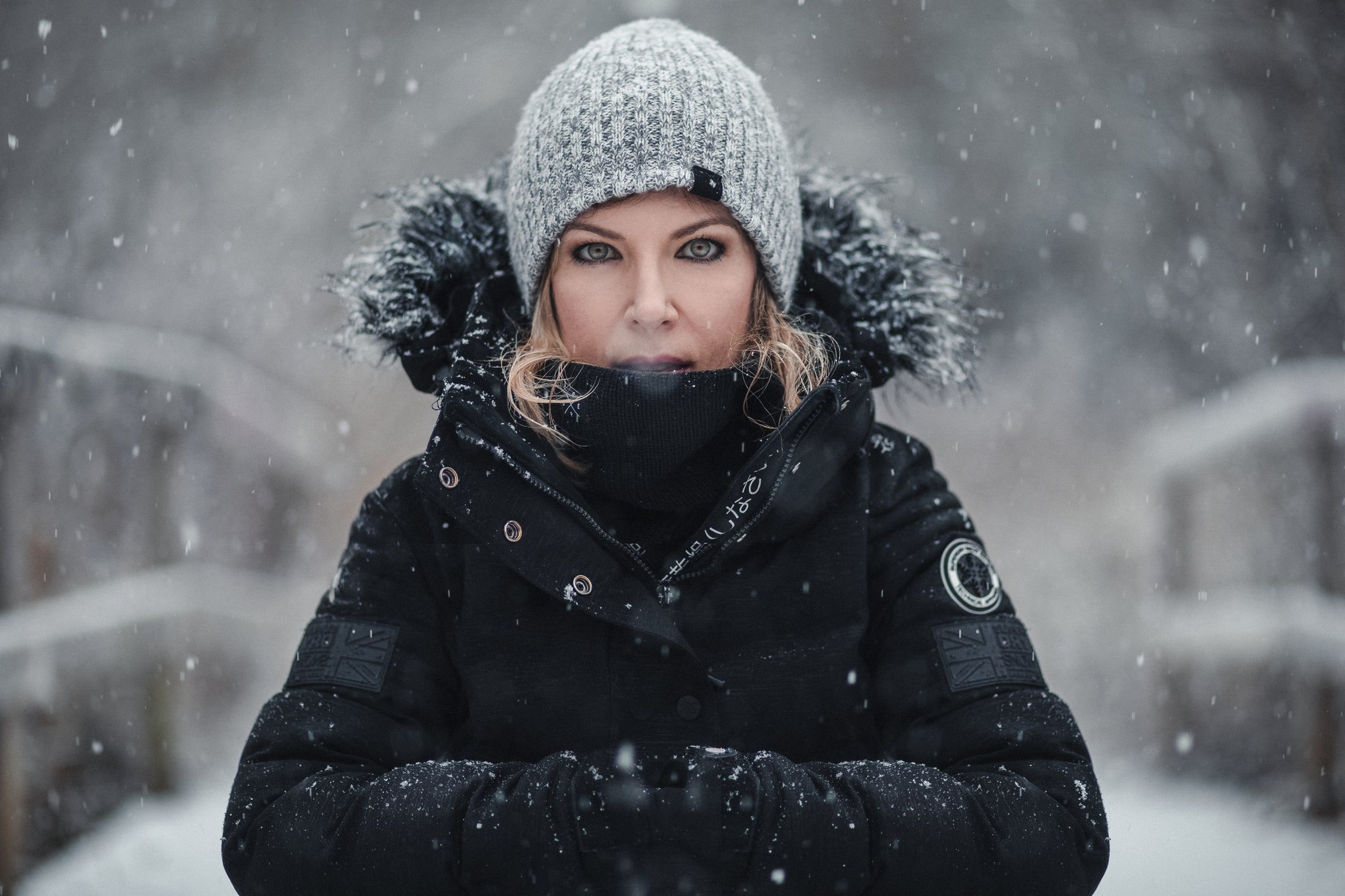 Individual portrait of a woman standing in falling snow.