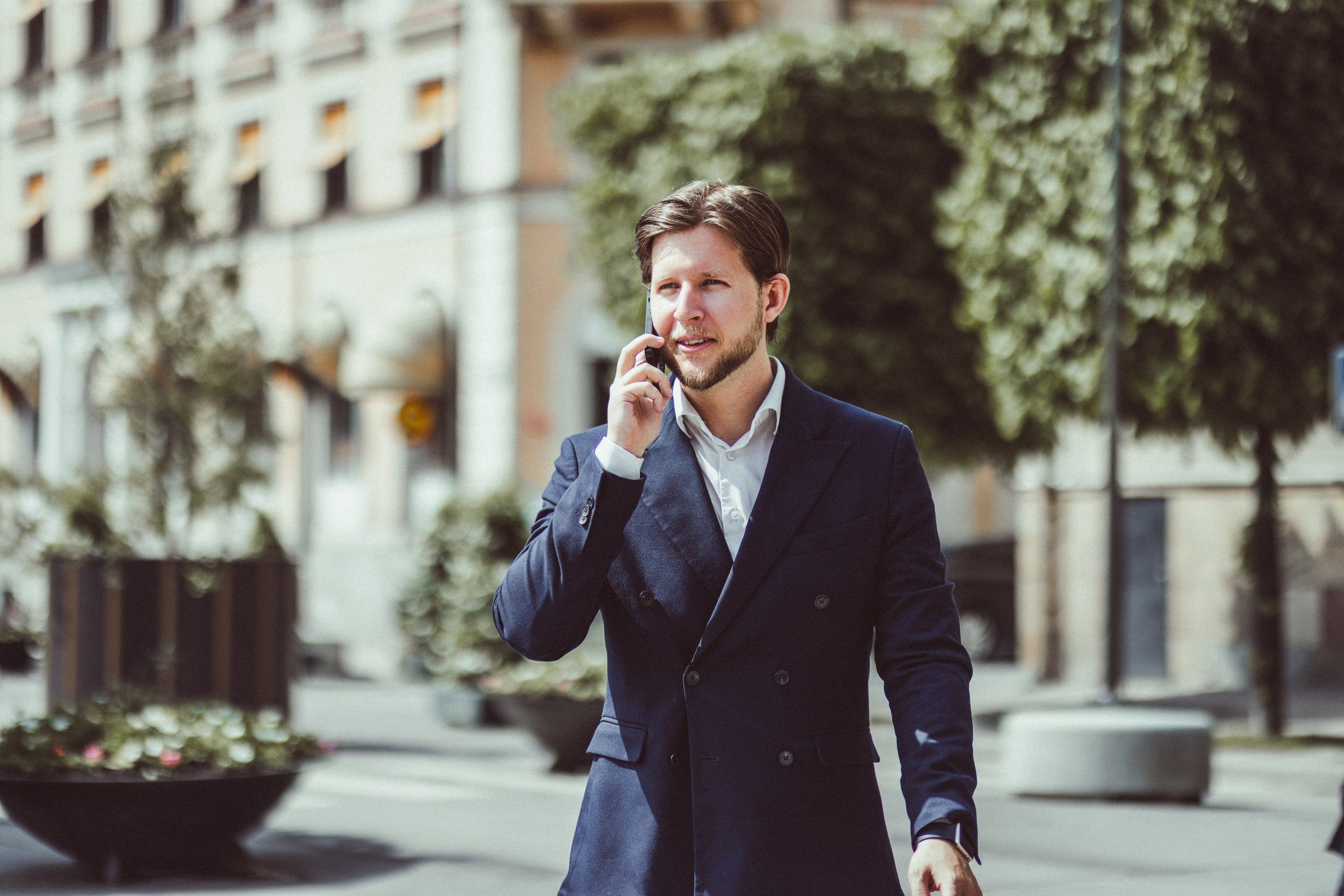 Concierge walking through the city while speaking on the phone.