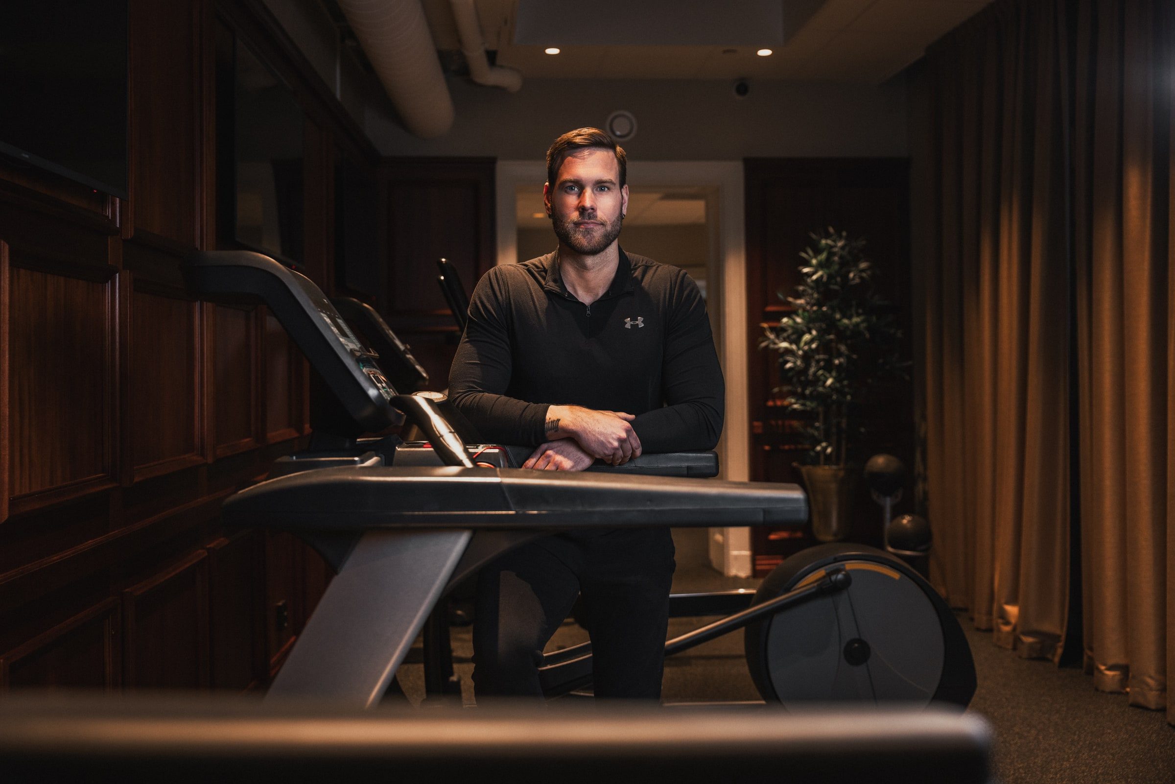 Wide environmental portrait of a personal trainer in his gym.
