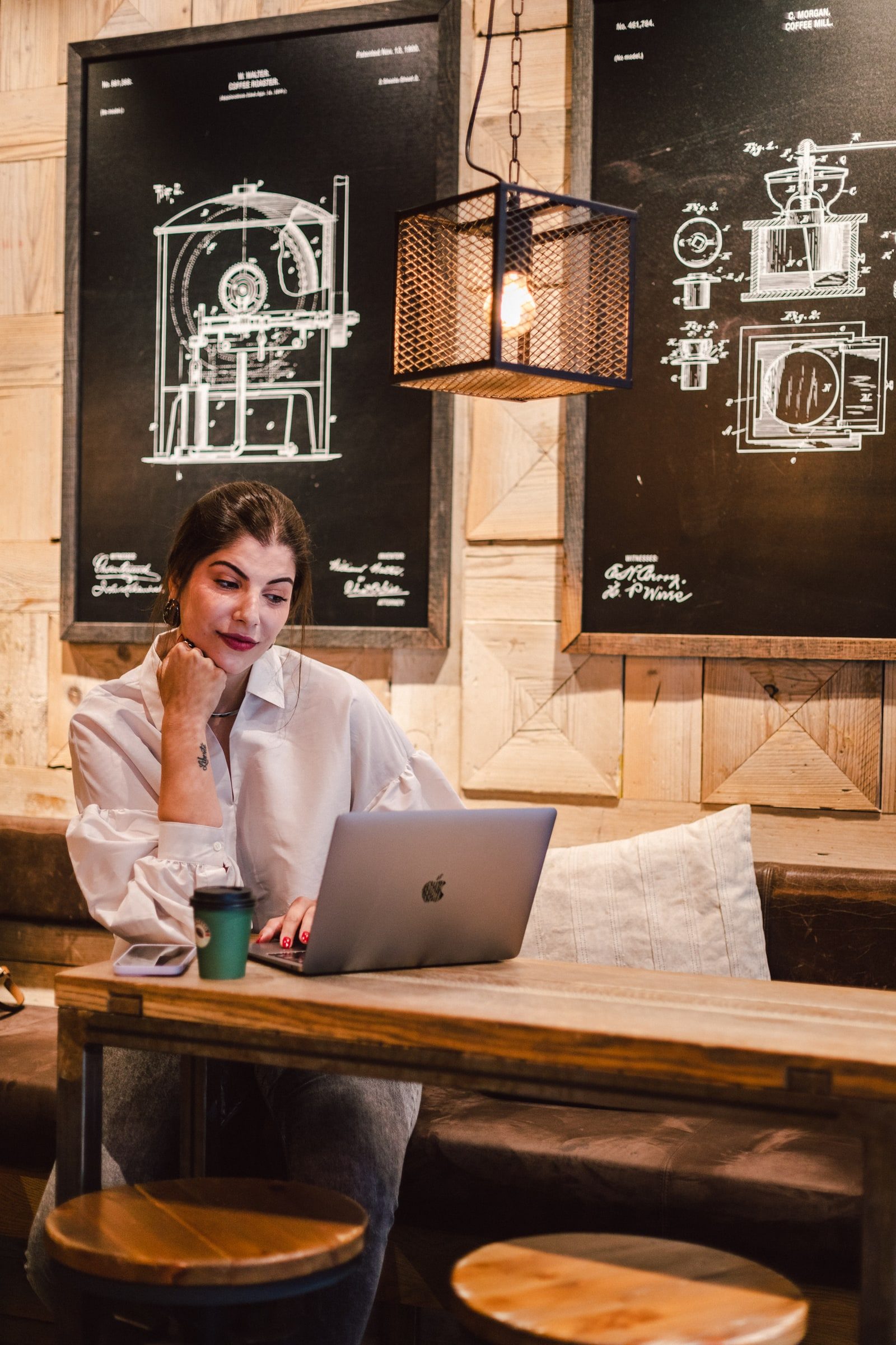Business coach working on a laptop at a café table.