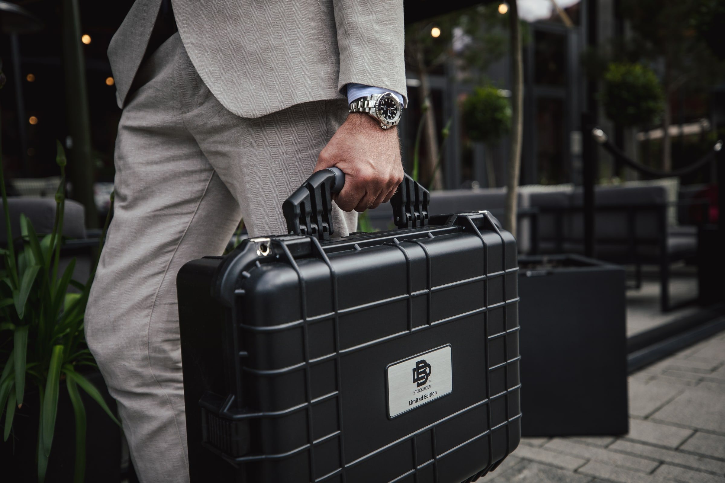 Professional carrying a branded case with a wristwatch in view.