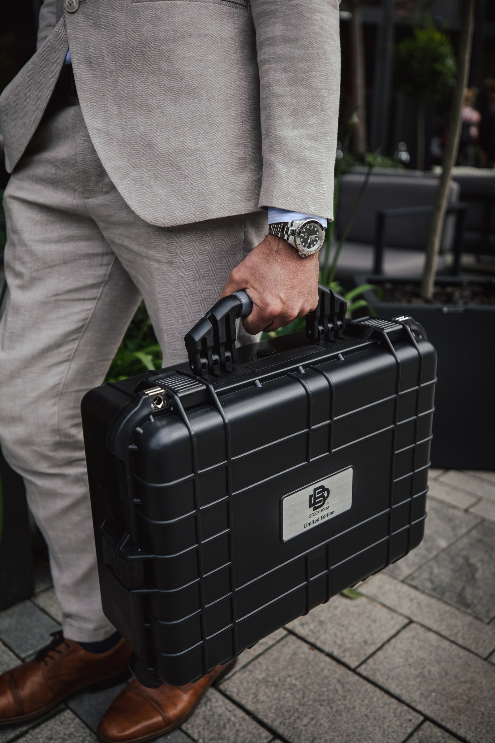 Wristwatch styled with a light suit and business case.